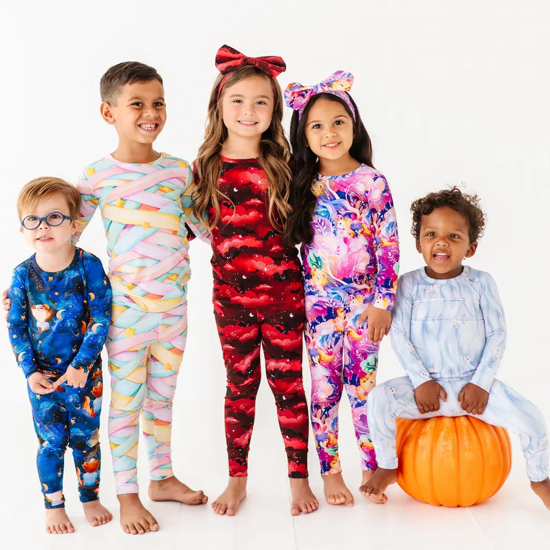 Five children wearing colorful pajamas on a white background