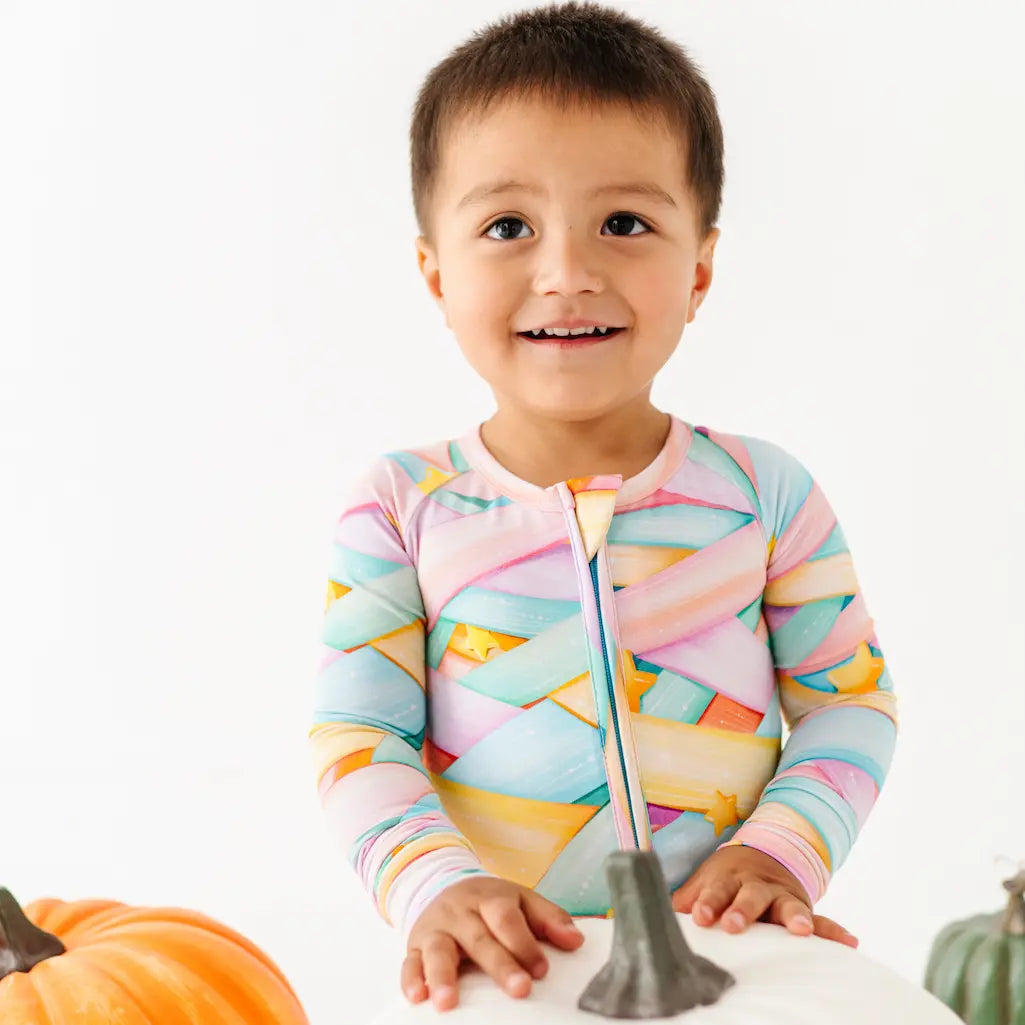 Person wearing orange pumpkin-patterned leggings on a light blue background