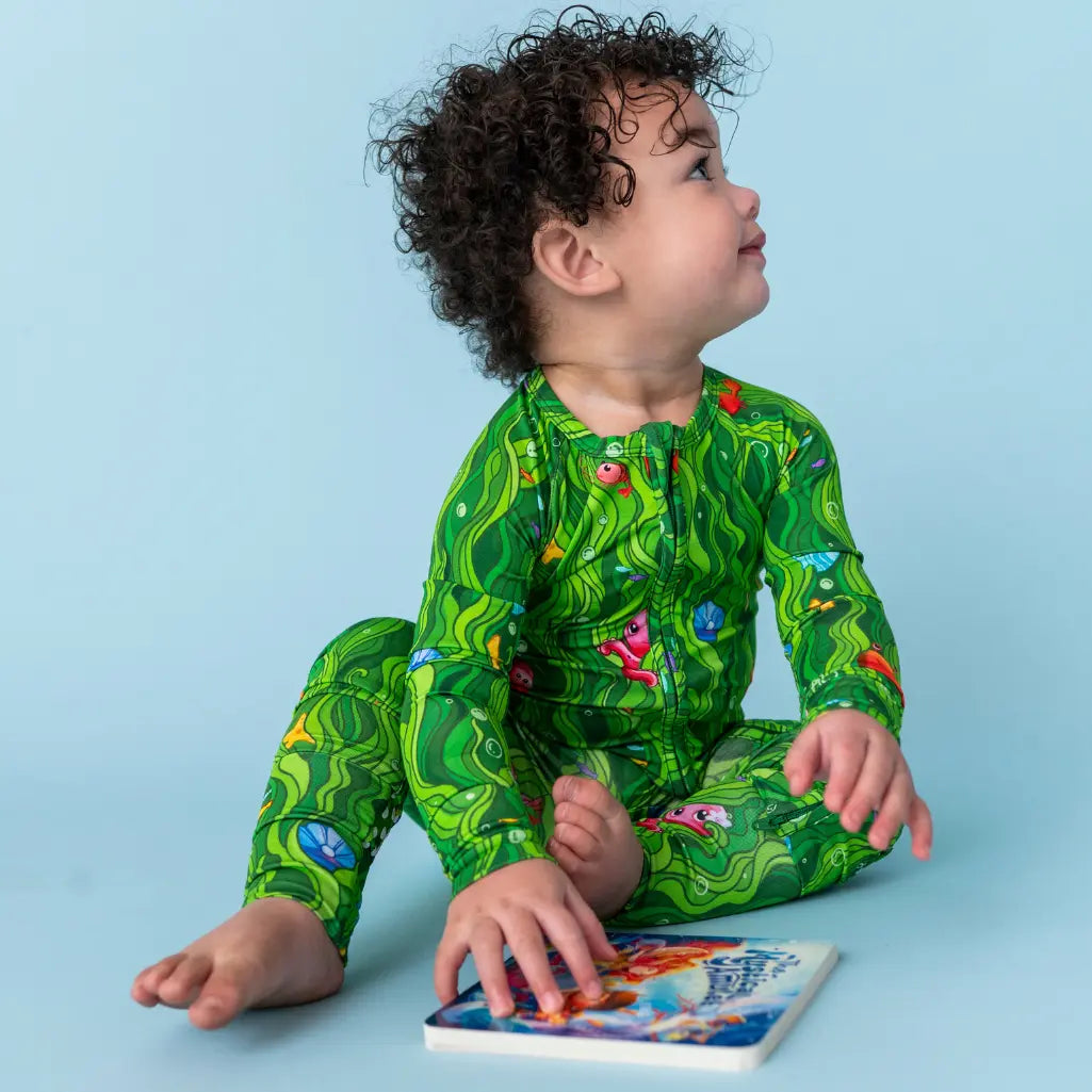 Child wearing a green dinosaur-themed outfit on a light blue background