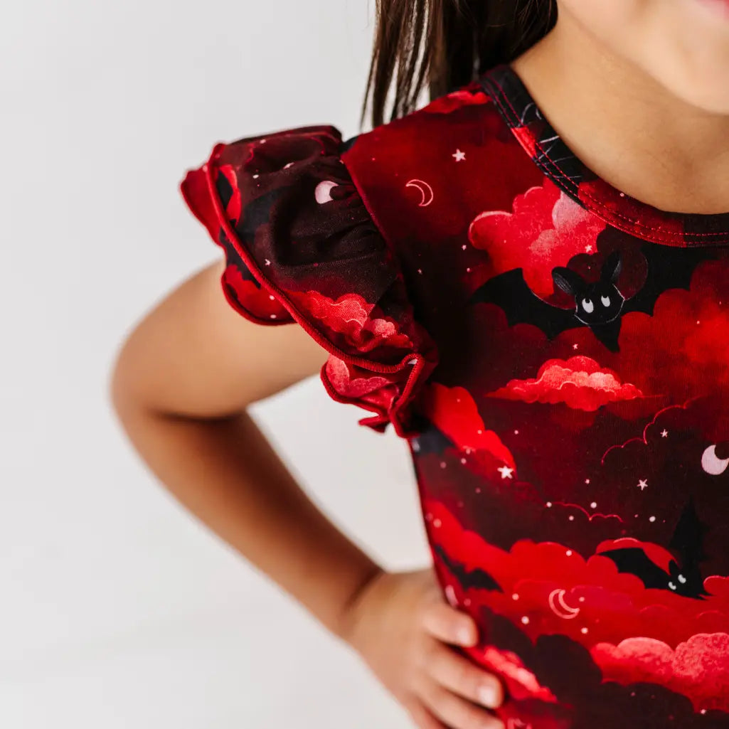 Red dress with black cat and moon design on a white background