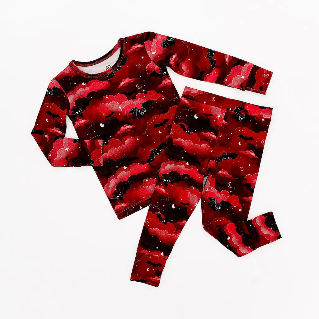 Red and black long-sleeve shirt and pants pajama set with an abstract cloud-like pattern displayed on a white background