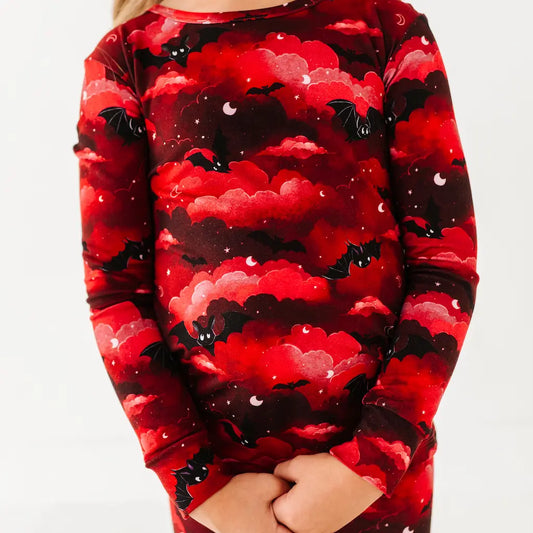 Red and black patterned shirt with bats and clouds on a white background
