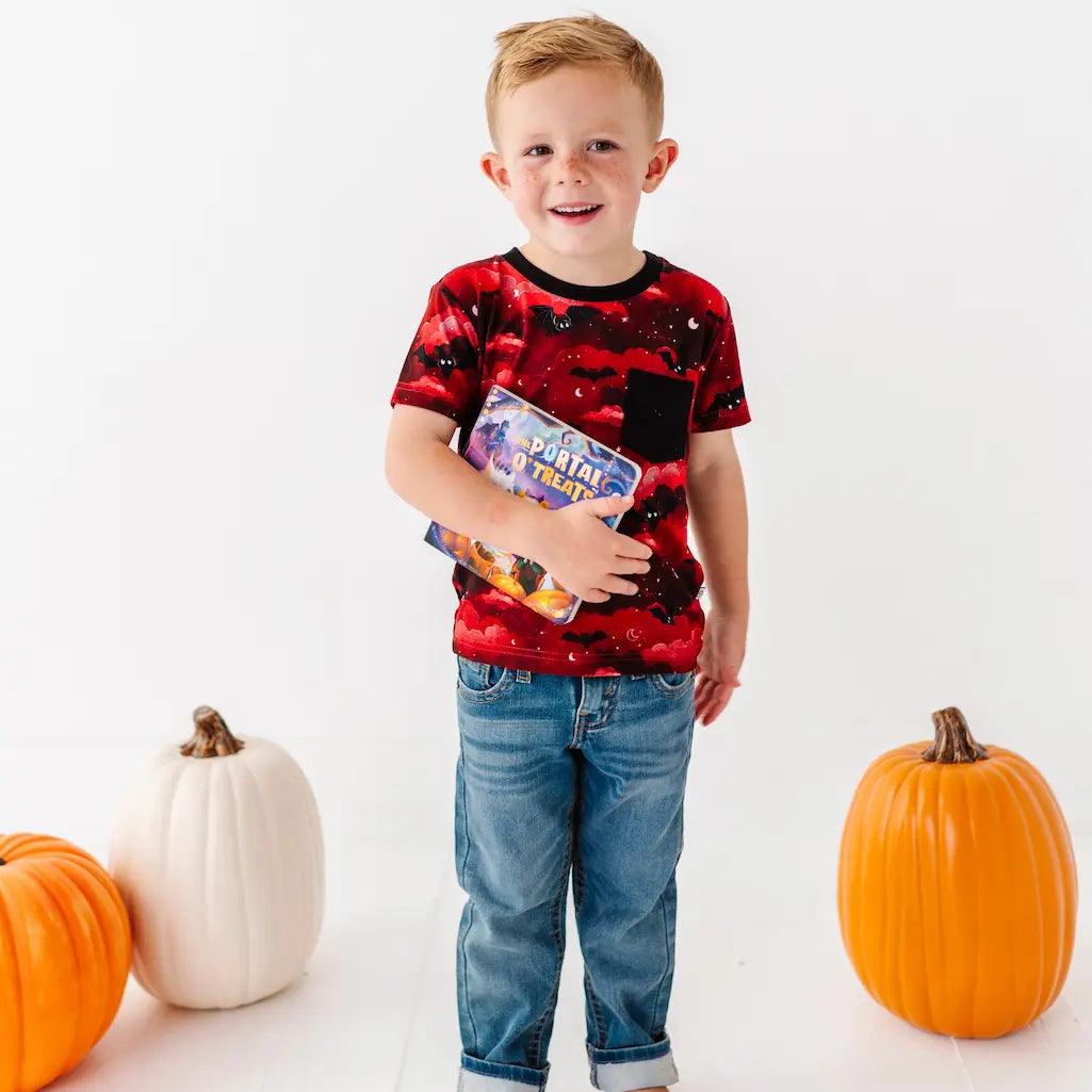 Child wearing a red graphic t-shirt with pumpkins on a white background