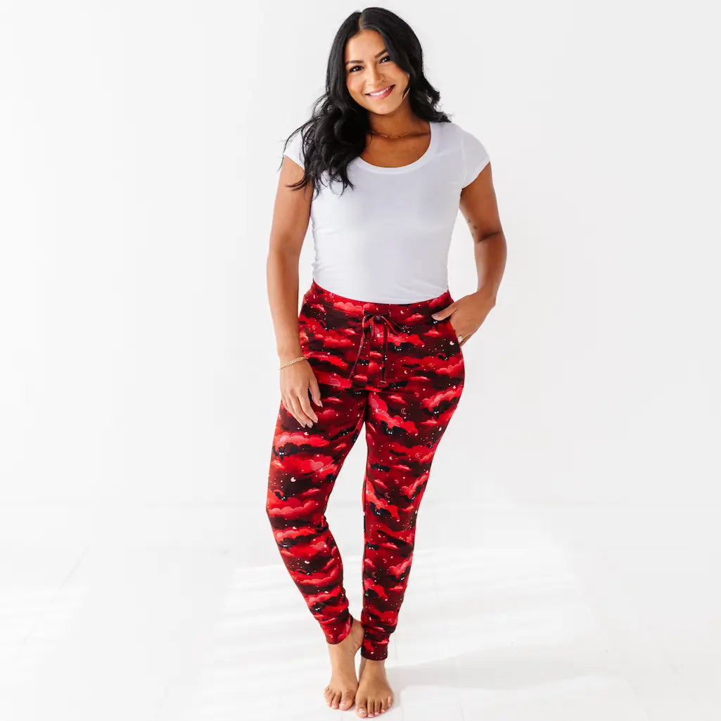 Woman wearing red camouflage pants and a white top on a white background