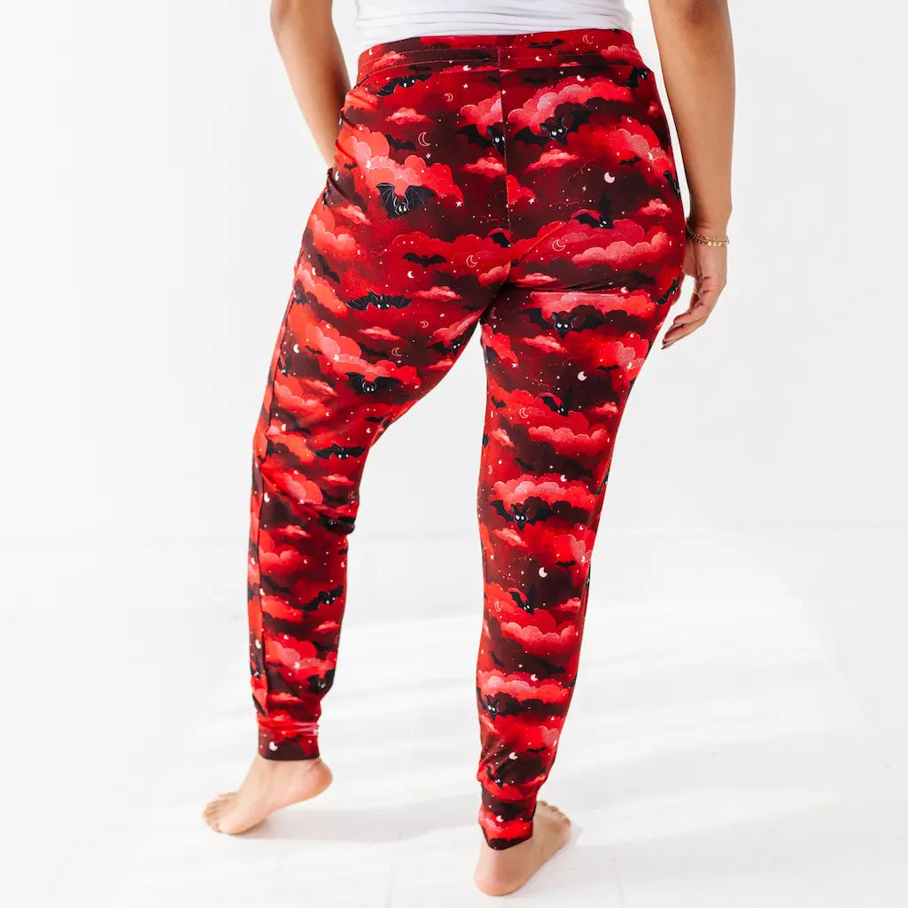 Red and black camouflage leggings worn by a person on a white background