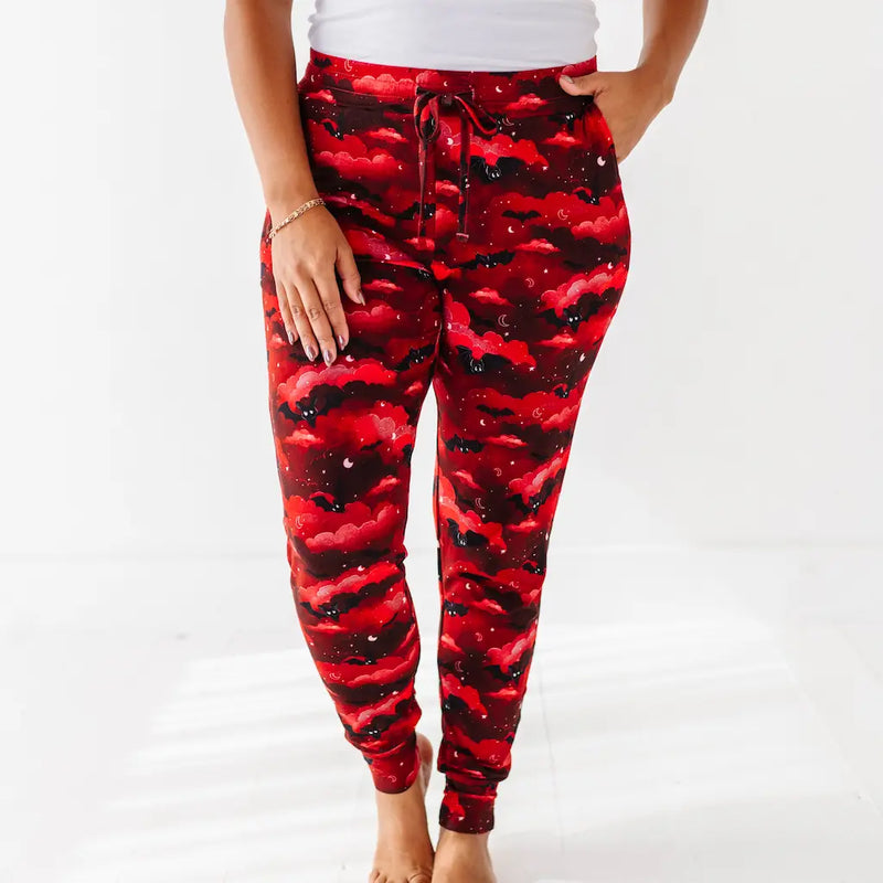 Red and black camouflage pants worn by a person on a white background
