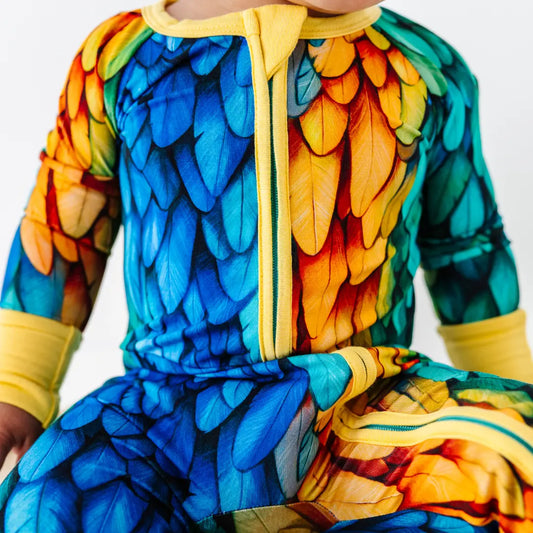 Colorful parrot-themed onesie on a child against a white background
