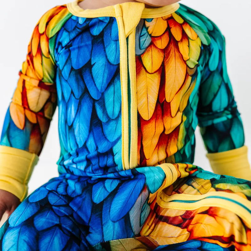 Colorful parrot-themed onesie on a child against a white background
