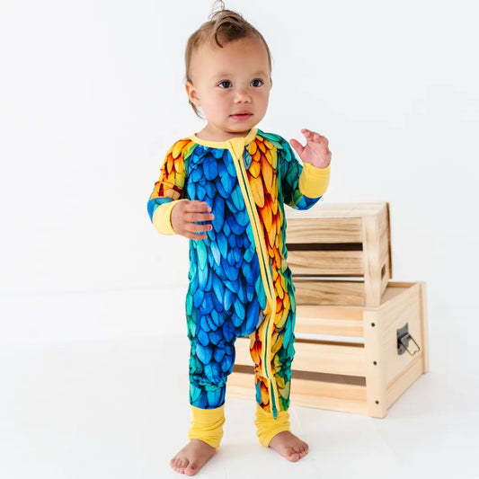 Baby wearing a colorful onesie with a wooden crate in the background