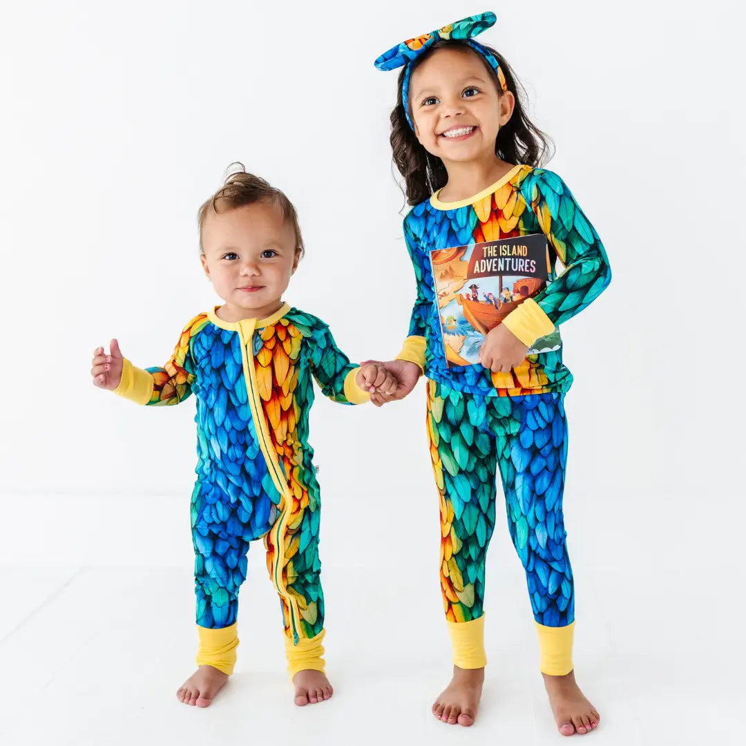 Two children wearing colorful pajamas with a white background