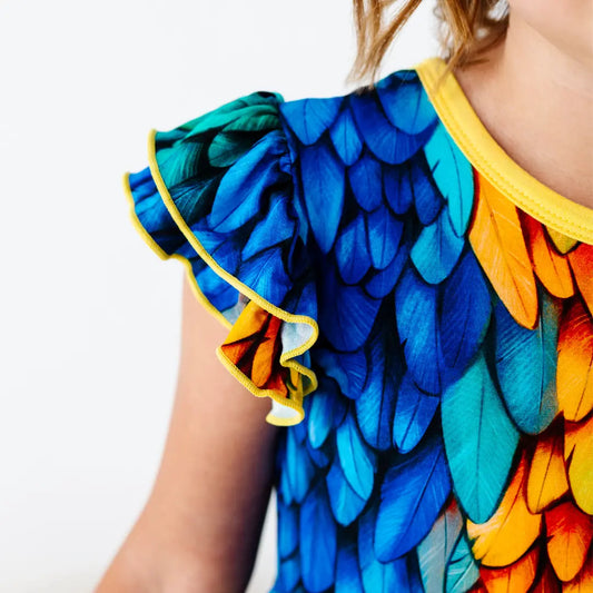 Colorful feather-patterned dress with blue, orange, and green on a white background