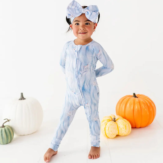 Child wearing a blue tie-dye onesie with pumpkins on a white background