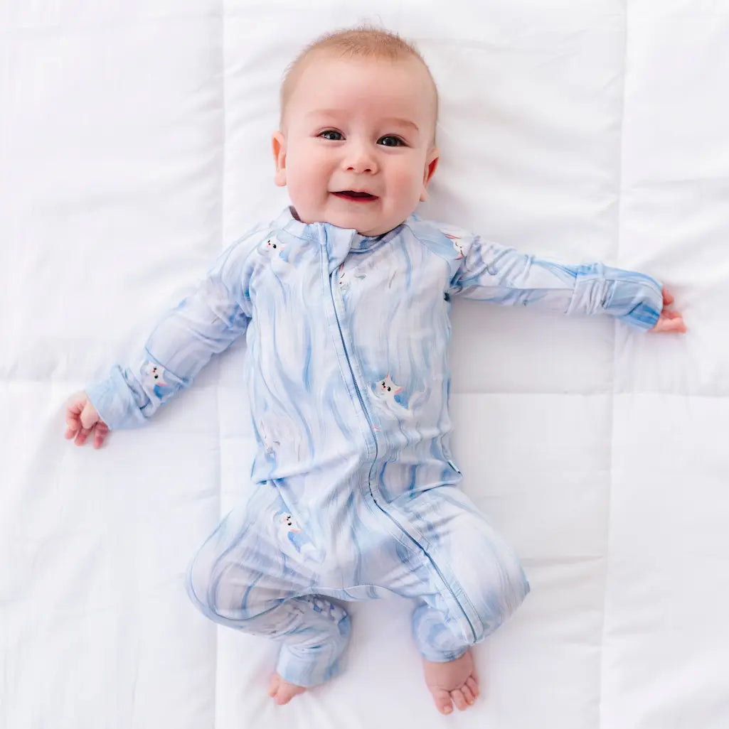Baby wearing a blue tie-dye onesie on a white background