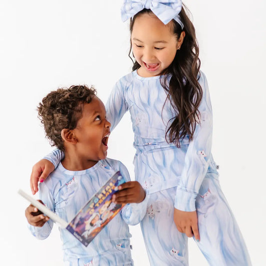 Two children in matching pajama sets with a white background