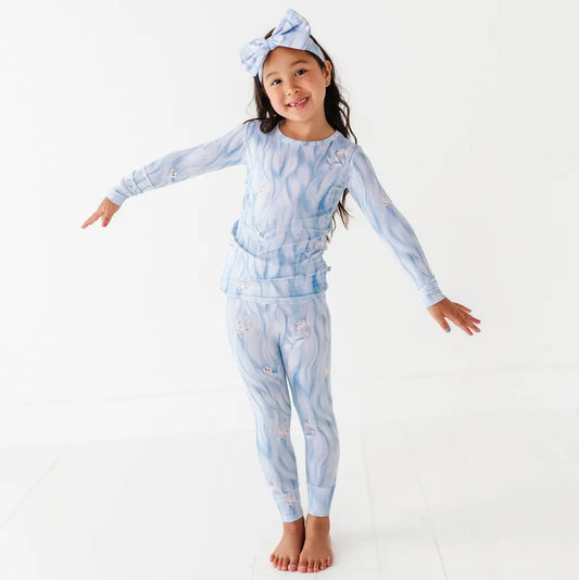 Child wearing a blue tie-dye outfit with a matching headband on a white background