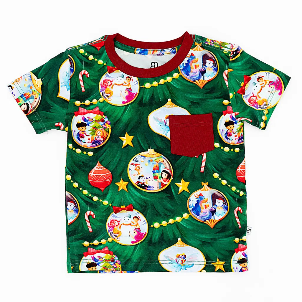 Green t-shirt with Christmas-themed design featuring cartoon characters and ornaments on a white background.