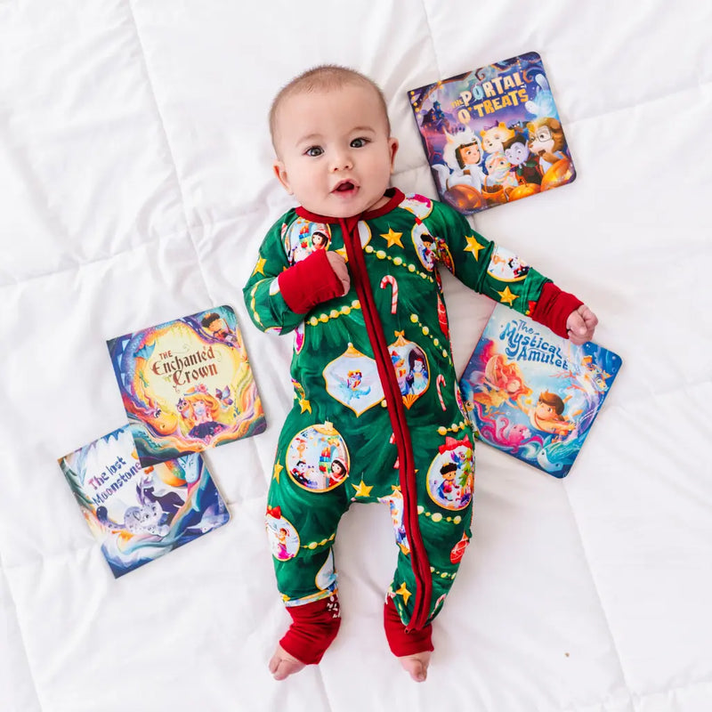 Baby in a colorful onesie surrounded by books on a white blanket