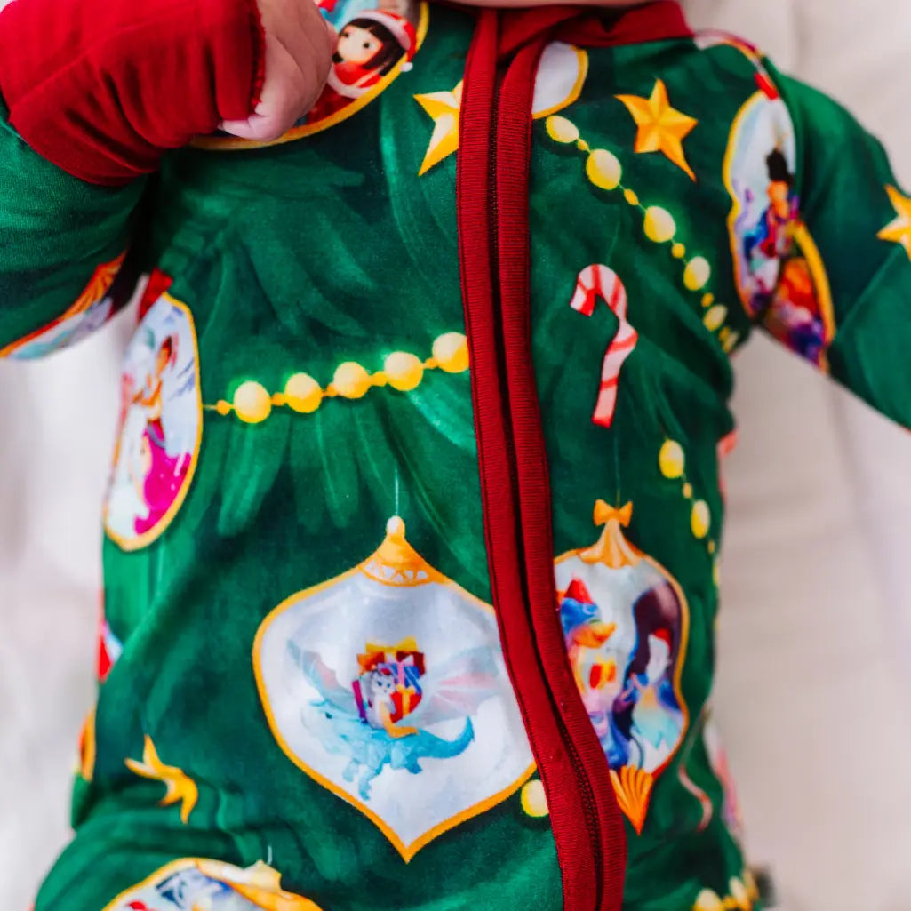 Child wearing a festive green onesie with colorful designs on a neutral background