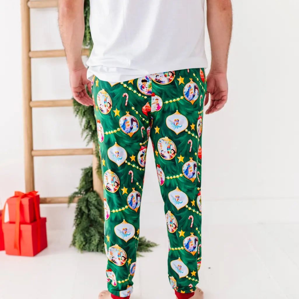 Person wearing festive green pajama pants with Christmas-themed designs in a home setting.