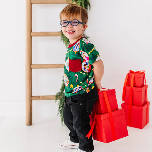 Child wearing a festive shirt with red gift boxes on a white background