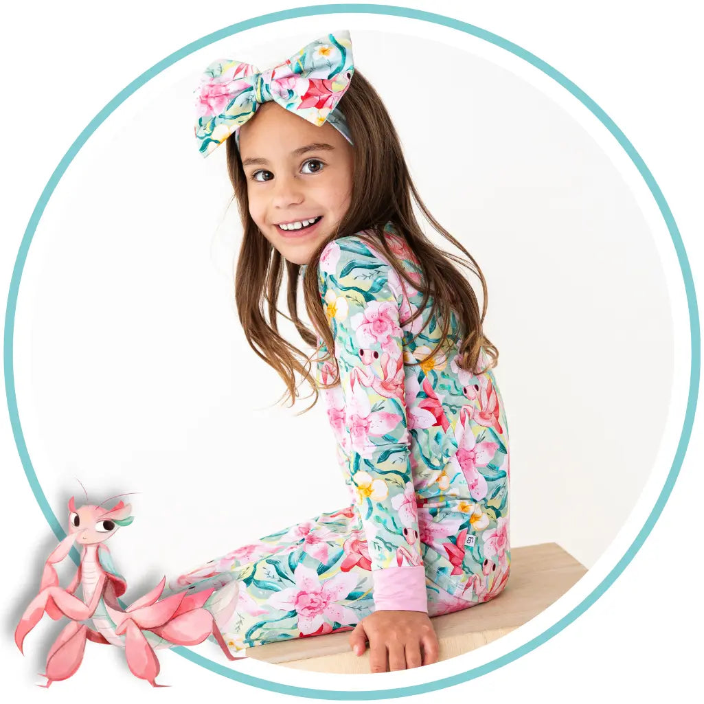 Young girl in a floral outfit with a pink toy on a white background