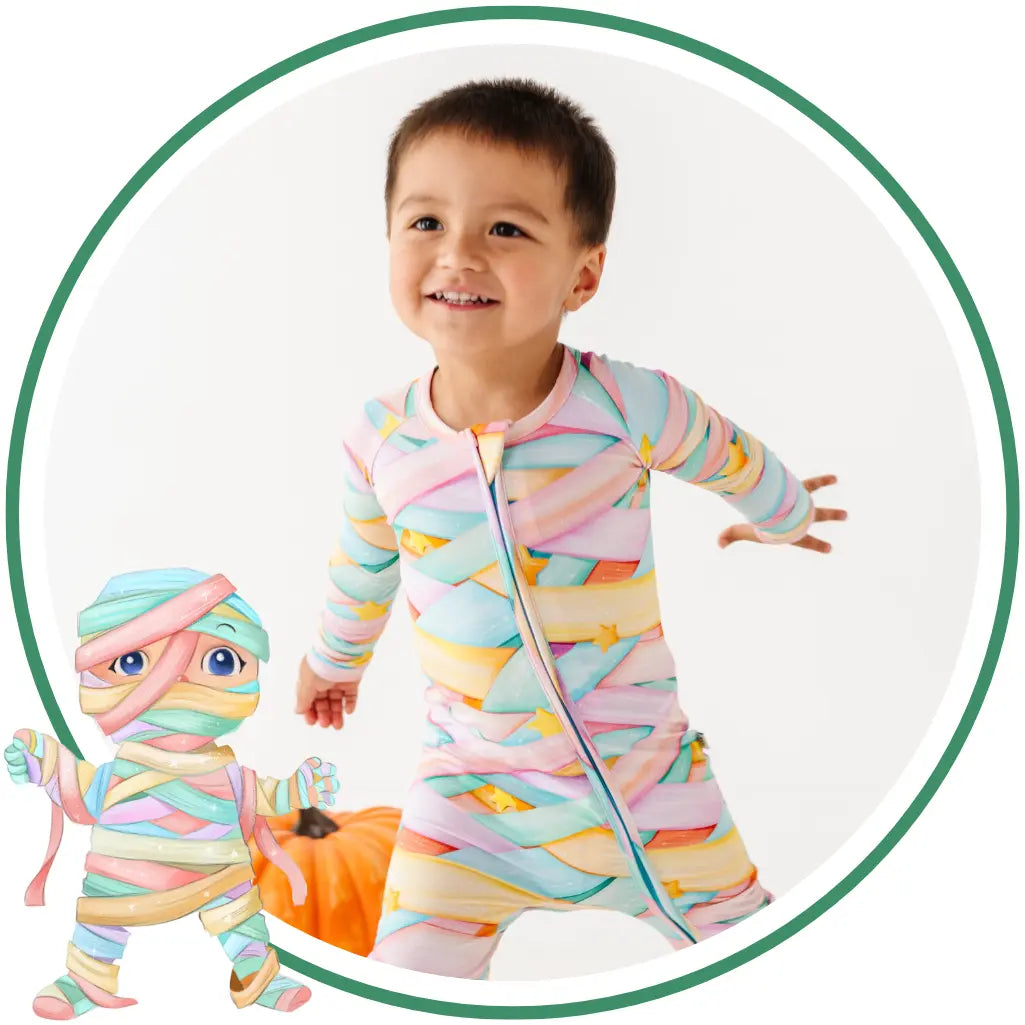 Child wearing a colorful striped onesie with a small toy figure next to them.