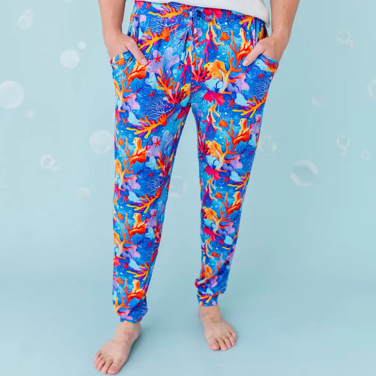 Colorful coral and fish patterned pants on a blue background.