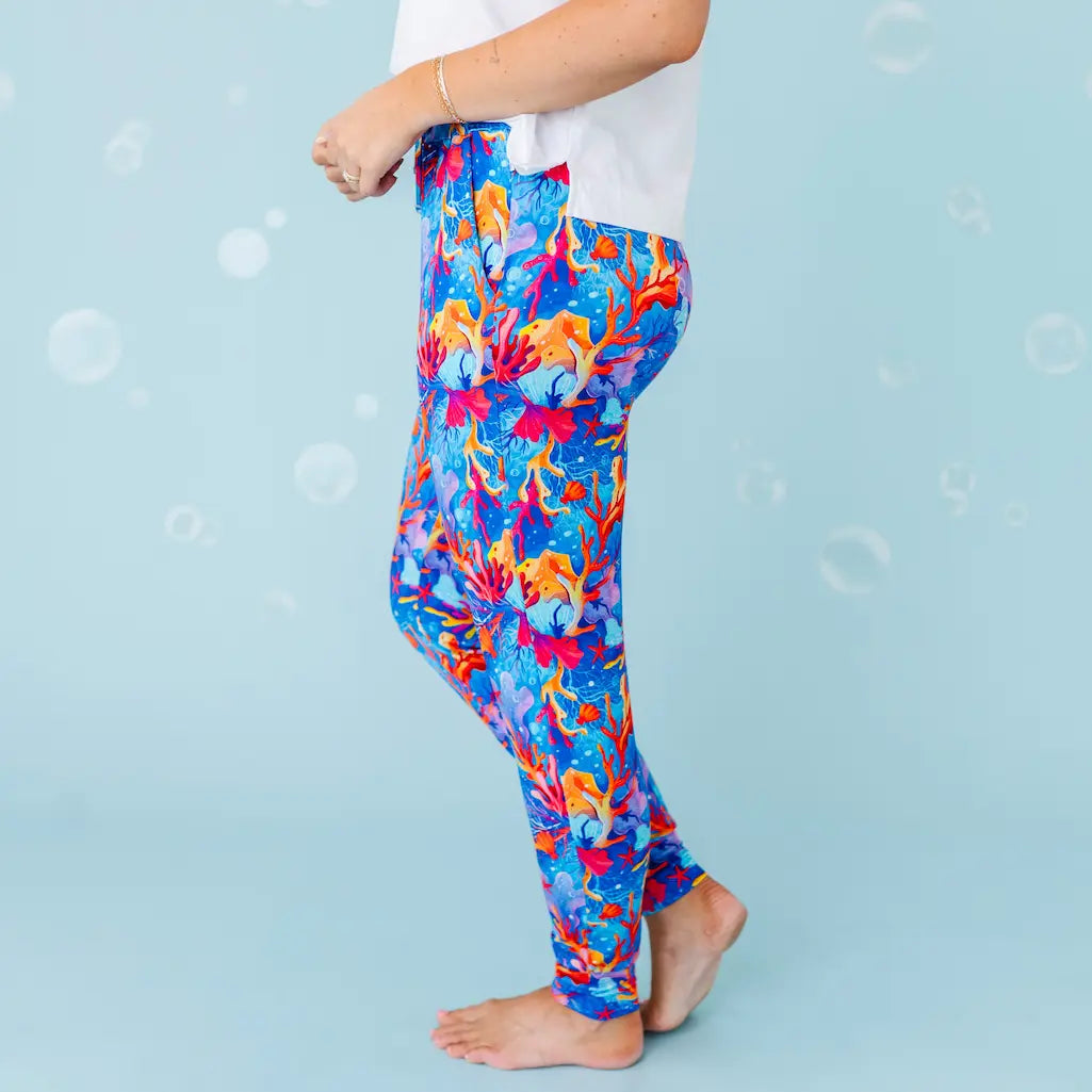 Colorful abstract-patterned leggings worn by a person on a light blue background.
