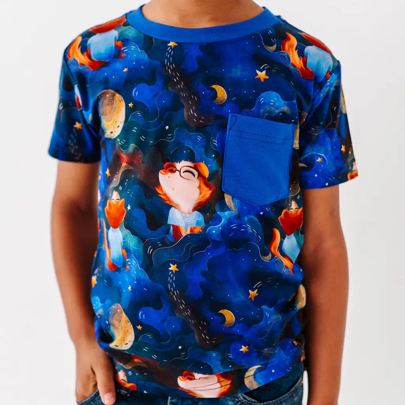 Child wearing a colorful t-shirt with a cartoon character design on a plain background