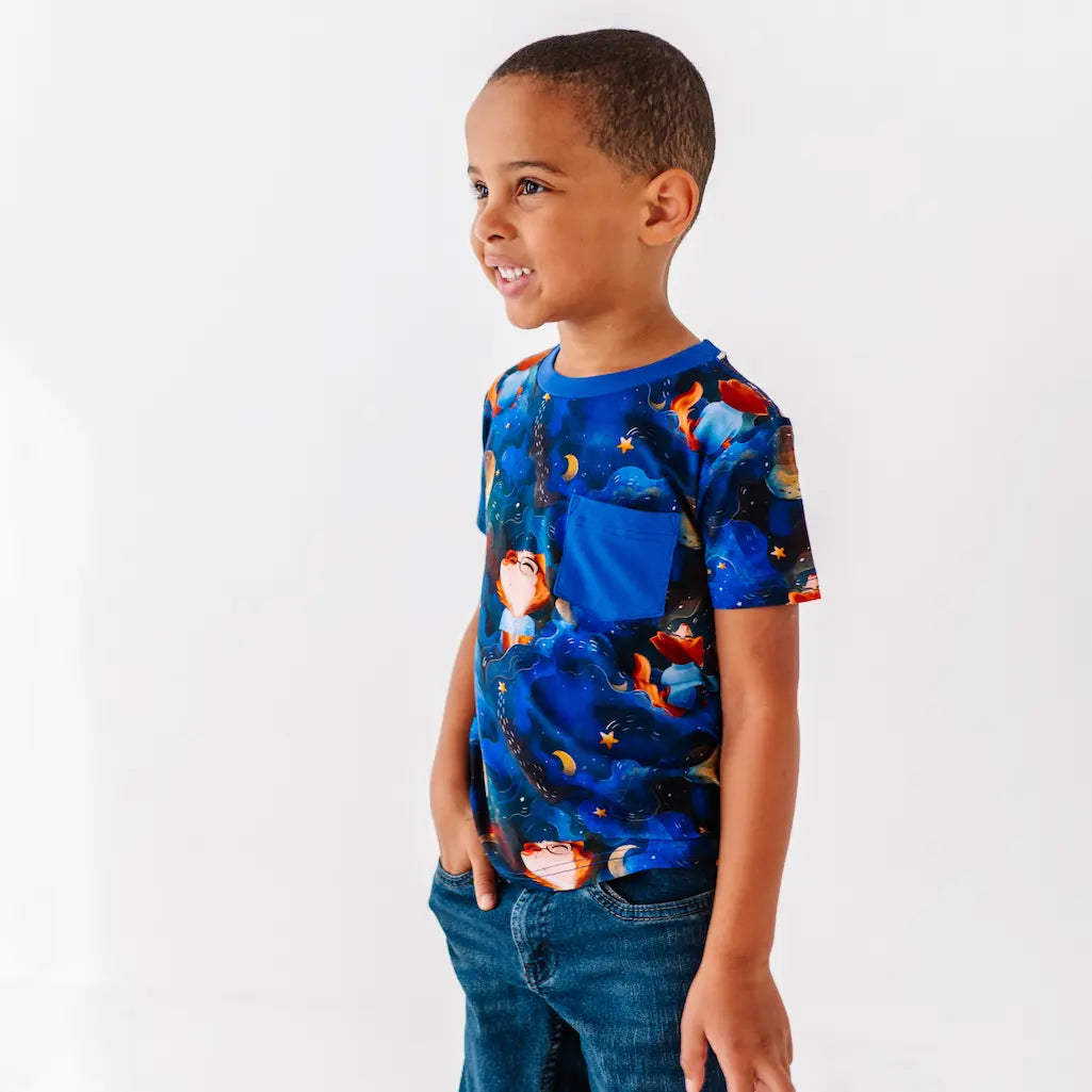 Child wearing a colorful t-shirt with a blue background