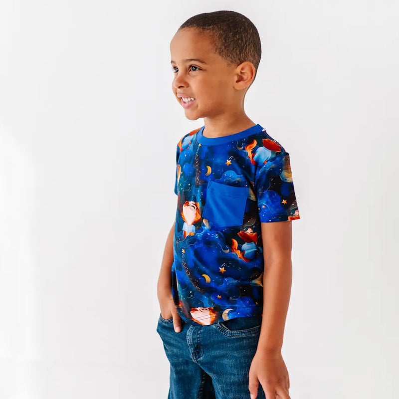Child wearing a colorful t-shirt with a blue background