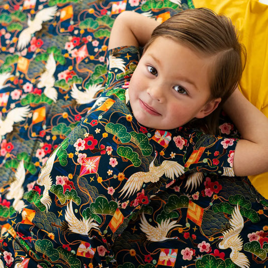 Child wearing a traditional embroidered garment with intricate designs.