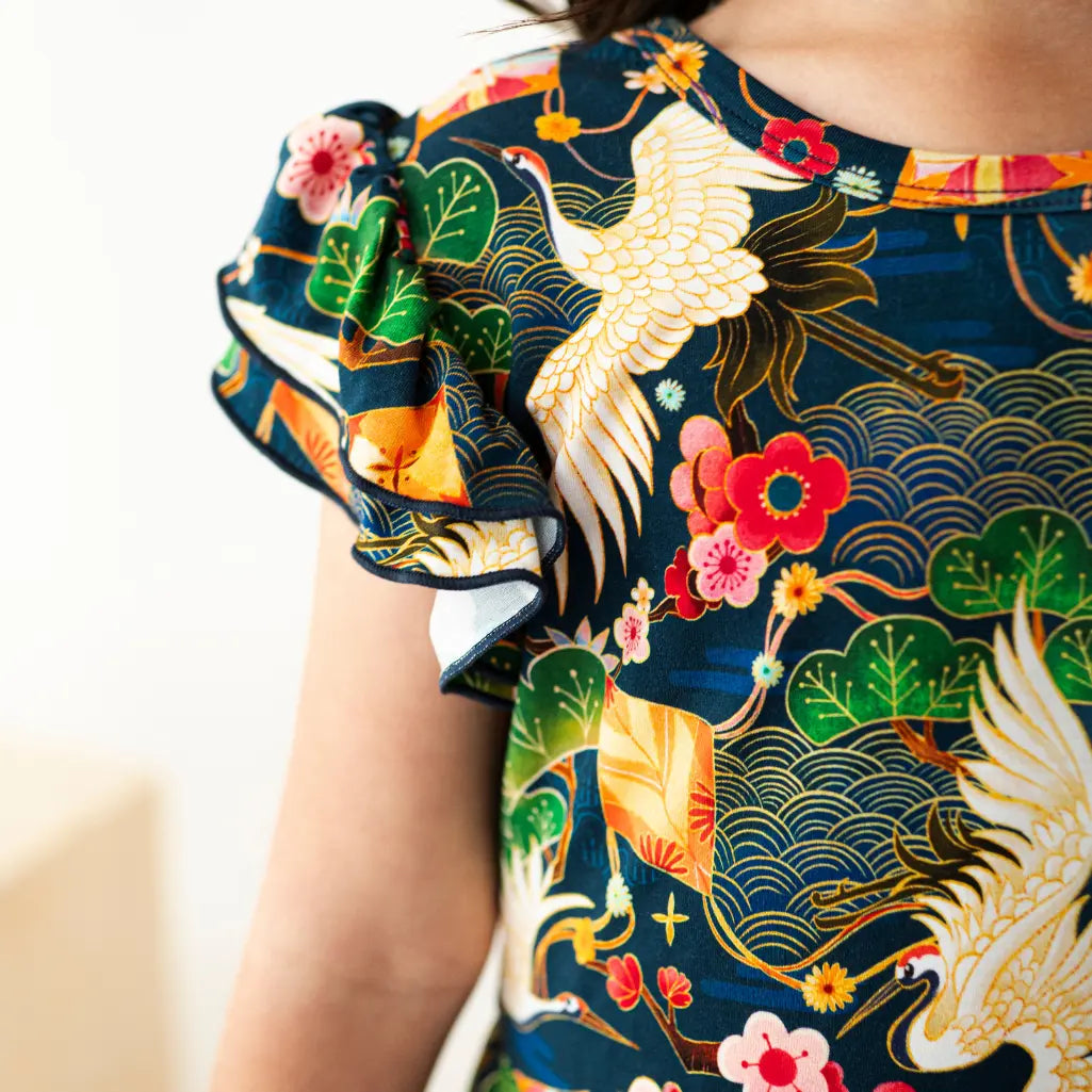 Close-up of a colorful traditional garment with floral and bird patterns.