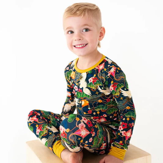 Child wearing a colorful pajama set with a dragon design on a white background