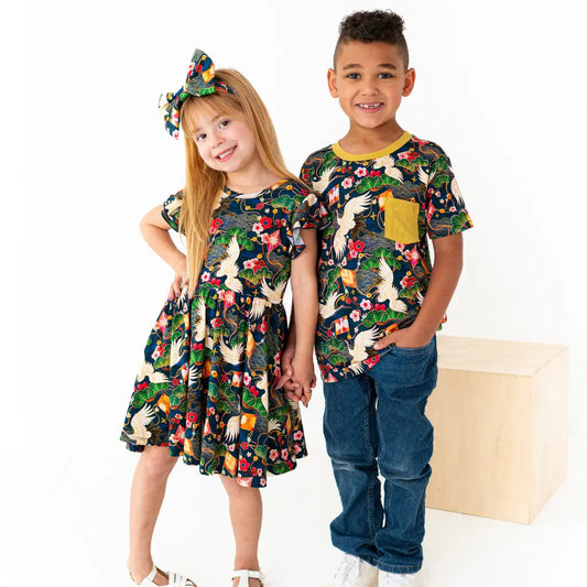 Two children wearing matching floral outfits on a white background