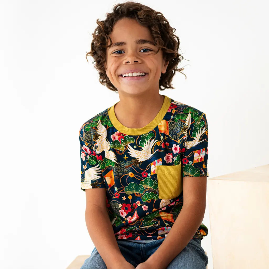 Child wearing a colorful patterned shirt with a white background