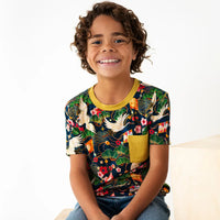 Child wearing a colorful patterned shirt with a white background