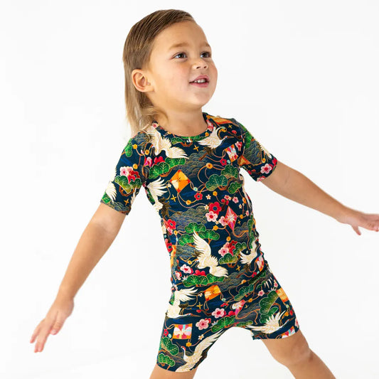 Child wearing a colorful dress with nature-themed design on a white background