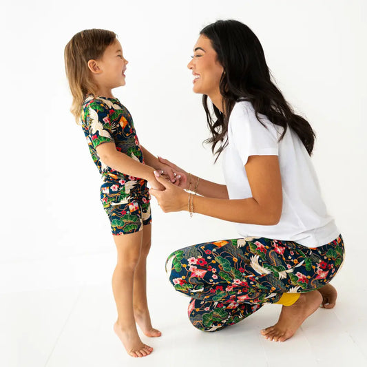 Woman and child wearing matching floral outfits on a white background