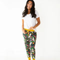 Woman wearing a white t-shirt and colorful floral pajama pants with yellow drawstring on a white background