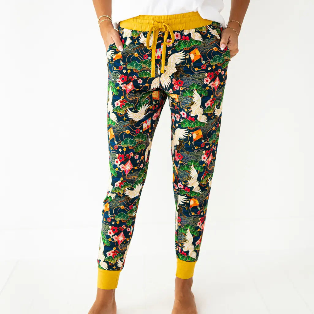 Colorful floral and bird patterned pants with yellow drawstring and cuffs on a white background