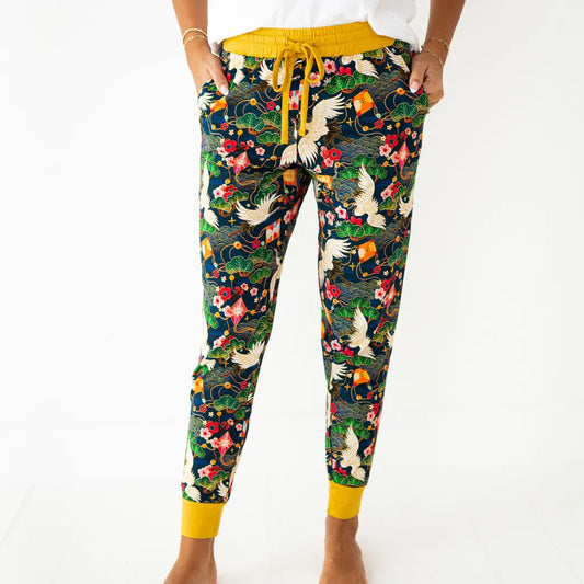 Colorful floral and bird patterned pants with yellow drawstring and cuffs on a white background
