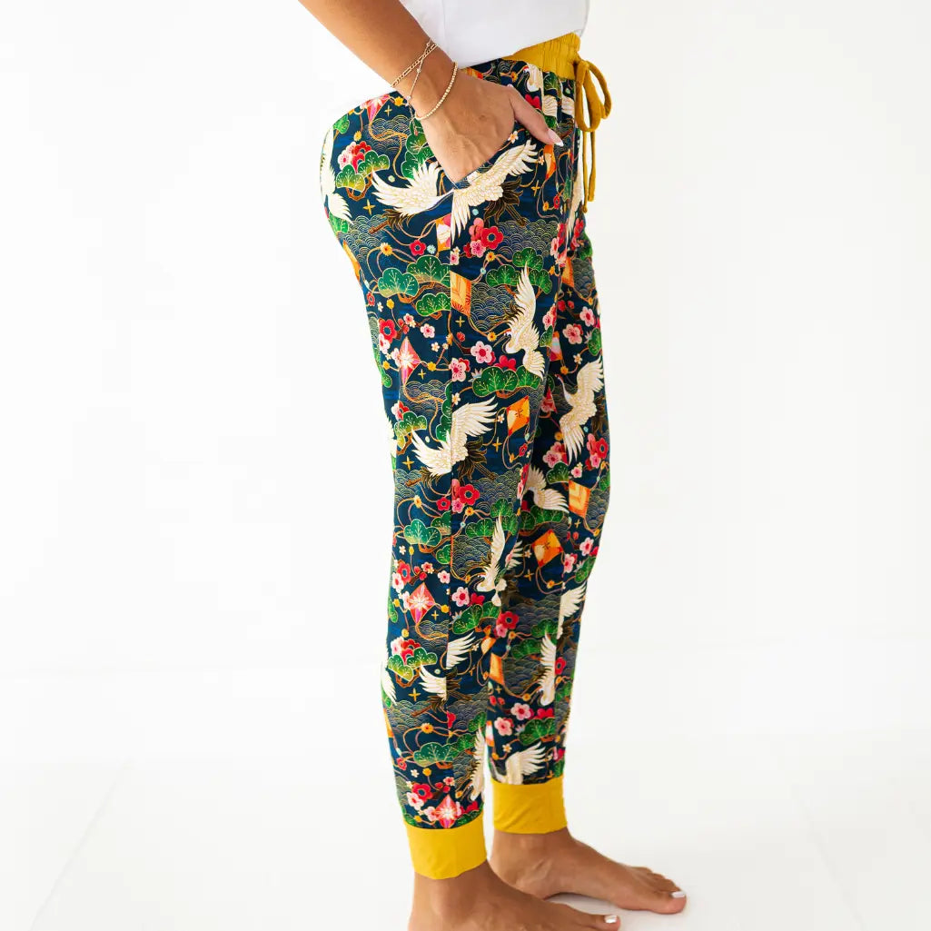 Colorful floral and bird patterned pants with yellow accents on a white background