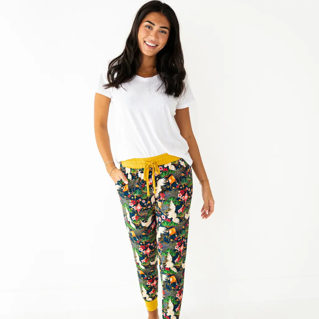 Woman wearing a white t-shirt and colorful floral pants on a white background