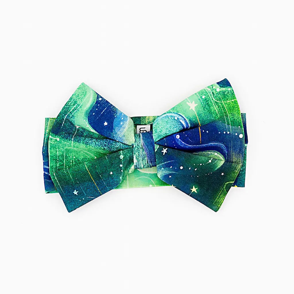Bow tie featuring a green and blue space-themed design with stars, displayed on a white background
