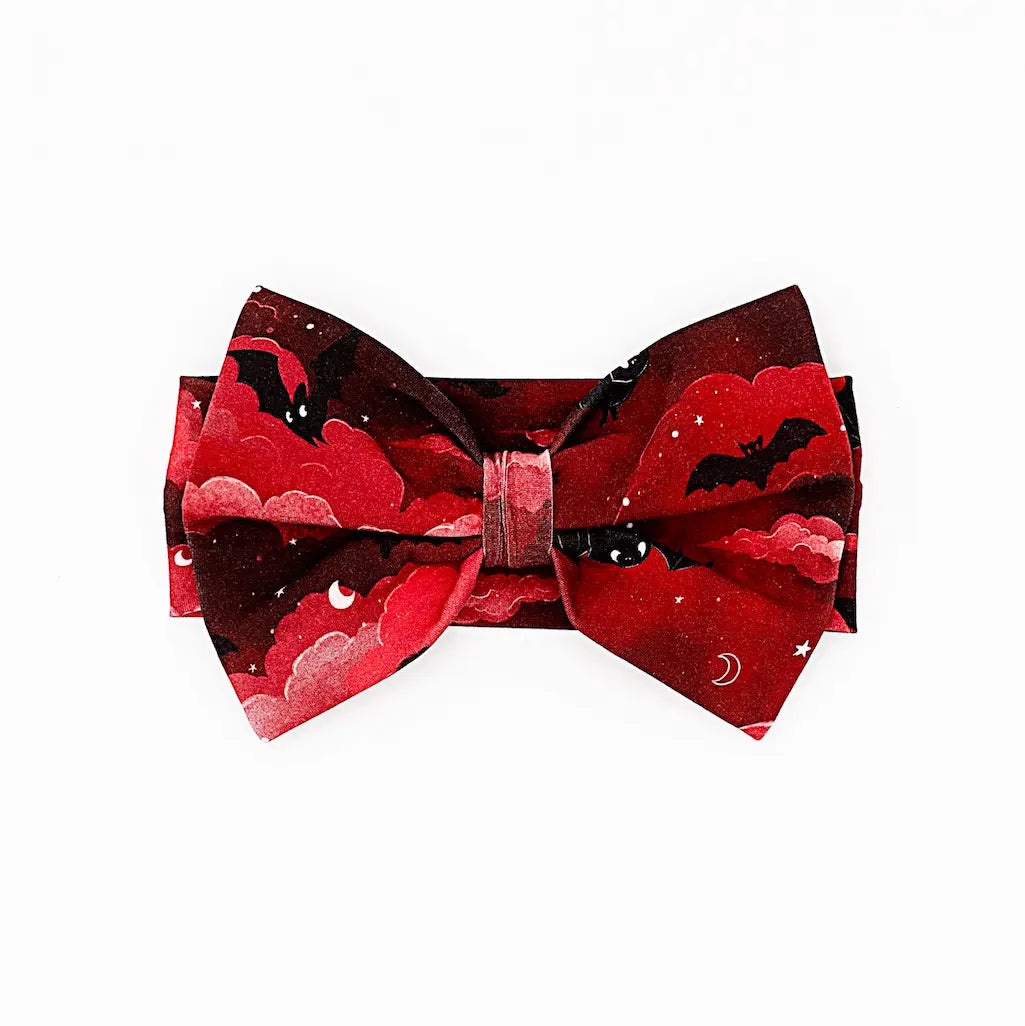 Red and black bow tie featuring a cloud and moon design with bats on a white background