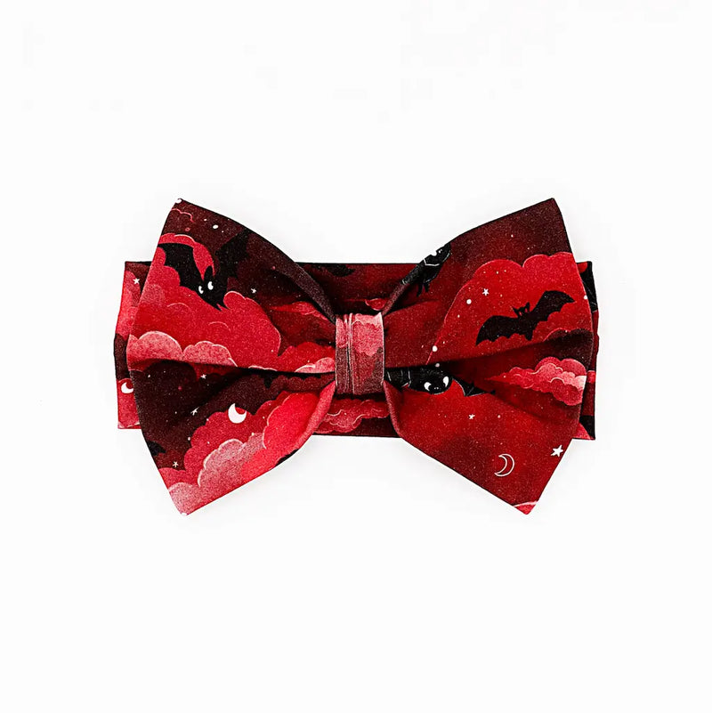 Red and black bow tie featuring a cloud and moon design with bats on a white background