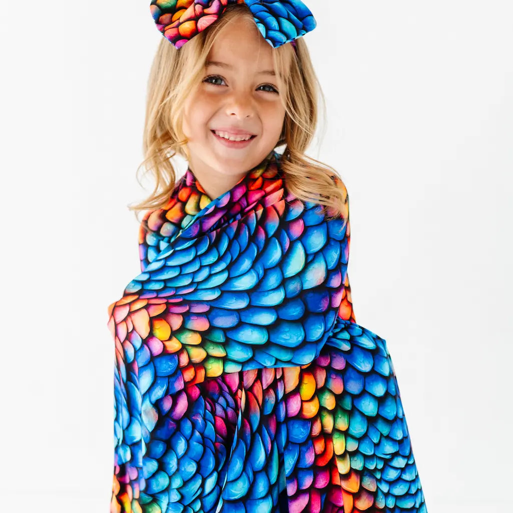 Child wearing a colorful scarf with a pattern on a white background