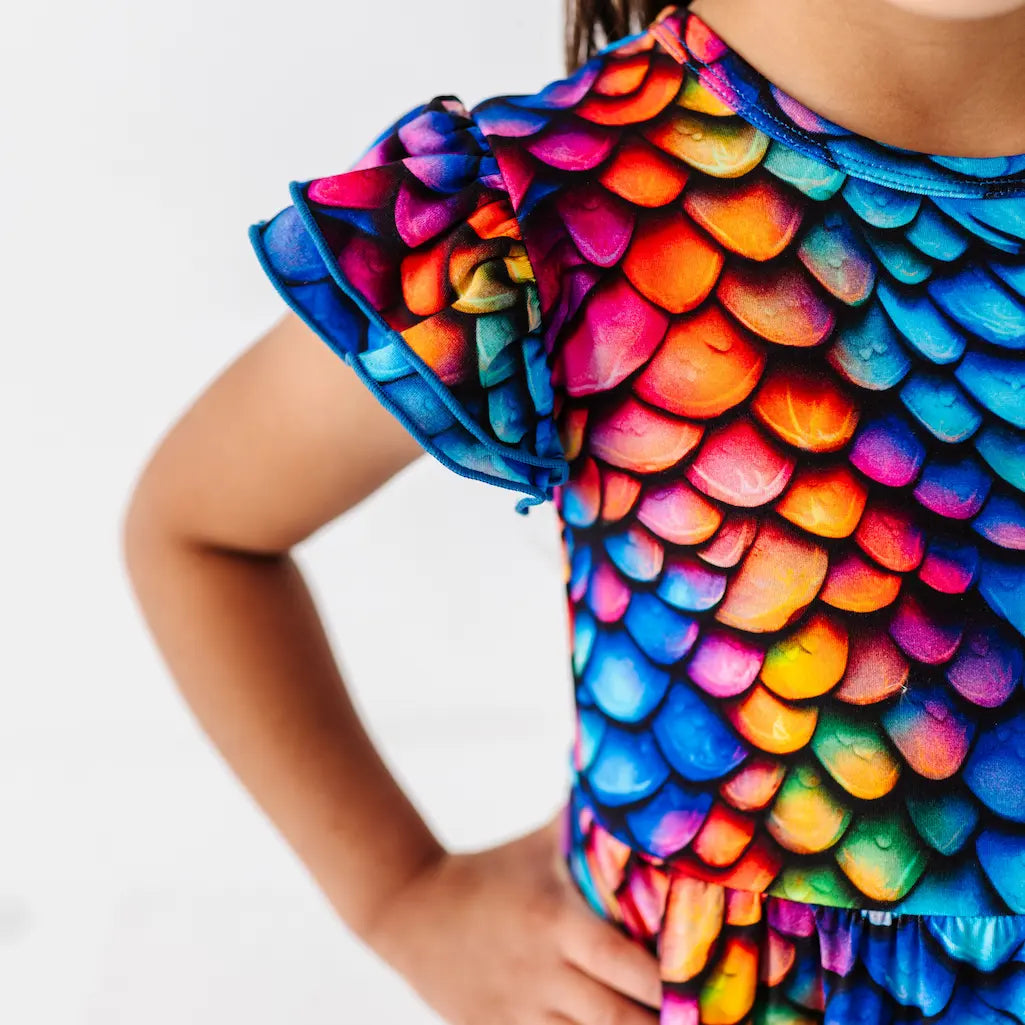 Colorful dragon scale pattern on a person wearing a sleeveless top.