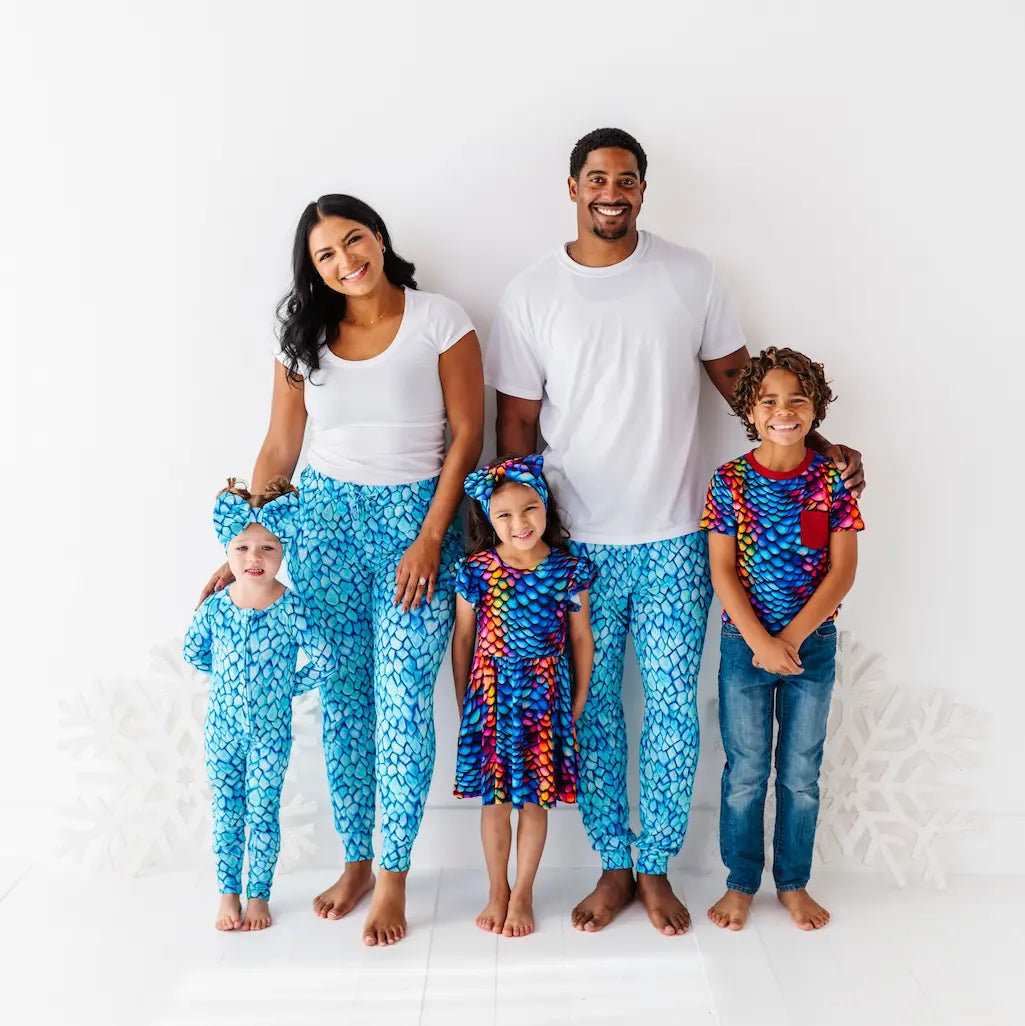 Family of five wearing matching blue pajama sets on a white background